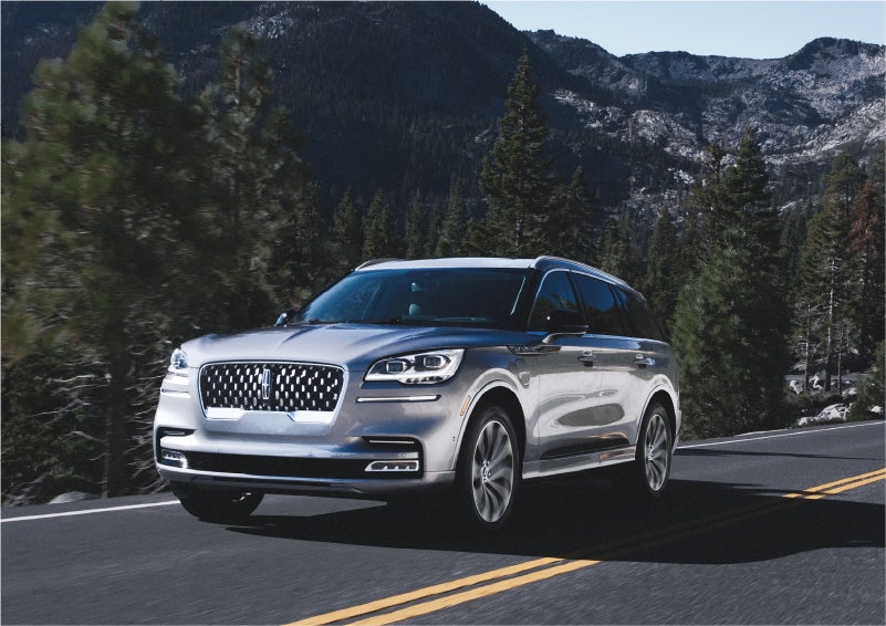 A 2023 Lincoln Aviator® Grand Touring SUV being driven on a winding road to demonstrate the capabilities of all-wheel drive | Thornhill Lincoln in Chapmanville WV