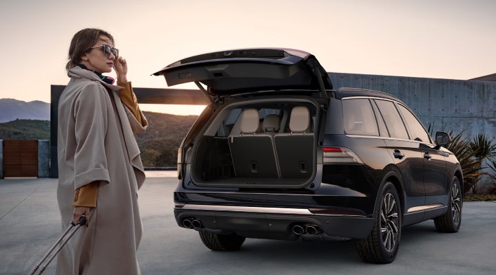 A woman approaches a 2026 Lincoln Aviator® SUV with its rear liftgate open. | Thornhill Lincoln in Chapmanville WV