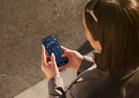 A person is shown interacting with a smartphone to connect to a Lincoln vehicle via the Lincoln Way® app. | Thornhill Lincoln in Chapmanville WV