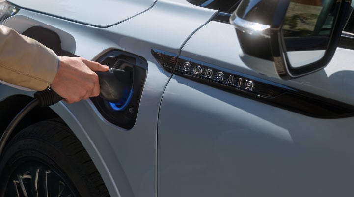 A hand is plugging in a 2026 Lincoln Corsair® Grand Touring Plug-in Hybrid SUV. | Thornhill Lincoln in Chapmanville WV